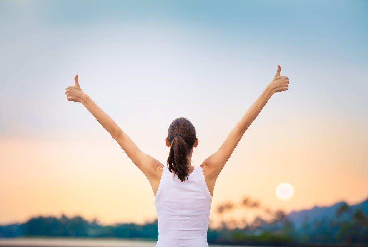 Femme au lever de soleil qui manifeste un signe de bonne santé hormonale et de bien-être.